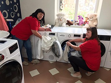Volunteers help refugees with laundry